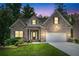 Lovely brick home exterior with a well-kept lawn, two-car garage, and welcoming entrance illuminated at dusk at 350 Paces Dr, Lithia Springs, GA 30122