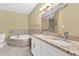 A full bathroom featuring a corner soaking tub, granite countertops, and a large mirror at 827 Fraser Se St, Atlanta, GA 30315