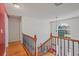The upstairs hallway features wood floors and a beautiful window overlooking the neighborhood at 3524 Forest Downs Cv, Decatur, GA 30034