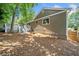 An exterior view of the home showcasing the spacious backyard with mature trees and fencing at 1080 Rackley Nw Way, Kennesaw, GA 30144