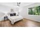 Bright bedroom with window view, wood-look floors, ceiling fan, and white walls at 1080 Rackley Nw Way, Kennesaw, GA 30144