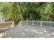 A spacious wooden deck with white railings surrounded by lush greenery, perfect for outdoor entertaining at 1080 Rackley Nw Way, Kennesaw, GA 30144