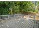 A spacious wooden deck with white railings surrounded by lush greenery, perfect for outdoor entertaining at 1080 Rackley Nw Way, Kennesaw, GA 30144