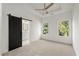 Bright bedroom with a barn door to the bathroom and two windows showing green trees at 2325 Mason Dr # D22, Atlanta, GA 30316