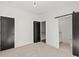 Cozy bedroom featuring neutral carpet, a barn door to bathroom, and dark modern doors at 2325 Mason Dr # D22, Atlanta, GA 30316