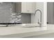 Close-up of kitchen sink and faucet with white countertops and stainless steel appliances at 2325 Mason Dr # D22, Atlanta, GA 30316