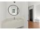Modern powder room with a round mirror, floating vanity, and hardwood floors at 2325 Mason Dr # D22, Atlanta, GA 30316