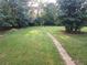 Expansive backyard surrounded by lush greenery featuring a playset and stone path at 3140 Kipling Dr, Powder Springs, GA 30127