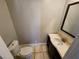 Cozy half bathroom featuring a sink vanity, toilet and tile flooring at 3140 Kipling Dr, Powder Springs, GA 30127