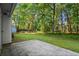 Large backyard featuring a concrete patio and a lush, wooded perimeter at 11006 Clearwater Dr, Hampton, GA 30228