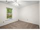 Bright bedroom showcases a large window with outdoor views and neutral carpeting at 11006 Clearwater Dr, Hampton, GA 30228