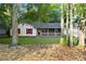 Front exterior view of home with mature trees, featuring red shutters, brick accents and an attached garage at 11006 Clearwater Dr, Hampton, GA 30228