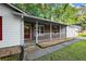 Charming front porch with brick accents and white railing, attached to a single-story home and garage at 11006 Clearwater Dr, Hampton, GA 30228