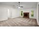Open living room featuring a fireplace, ceiling fan, and neutral carpet, perfect for relaxation and gatherings at 11006 Clearwater Dr, Hampton, GA 30228