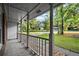 View of the white-columned porch with concrete floor looking out to the street and lush green lawn at 11006 Clearwater Dr, Hampton, GA 30228