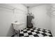 Practical utility room with black and white floors, sink, and overhead shelving at 11006 Clearwater Dr, Hampton, GA 30228