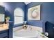 Bathroom features a soaking tub, arched window and white tile at 1208 Brandl Sw Dr, Marietta, GA 30008