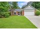 Beautifully landscaped front yard with a charming brick home and a two-car garage at 1208 Brandl Sw Dr, Marietta, GA 30008
