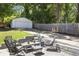 Backyard patio features outdoor furniture, a stone retaining wall and a view of the detached garage and driveway at 1297 Conway Rd, Decatur, GA 30030