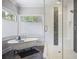 Modern bathroom featuring free standing tub, walk-in shower with mosaic accents, and bright natural lighting at 1297 Conway Rd, Decatur, GA 30030