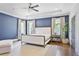 Elegant main bedroom with blue accent wall, tray ceiling, hardwood floors, and ample natural light at 1297 Conway Rd, Decatur, GA 30030