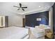 Stylish main bedroom featuring dark blue accent wall, ensuite bathroom, chaise lounge, and ceiling fan at 1297 Conway Rd, Decatur, GA 30030