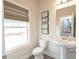 A stylish powder room with a pedestal sink and a window offers a touch of elegance at 3564 Shore Wood Ave, Lawrenceville, GA 30044