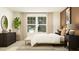 Bedroom features a bright window, dresser, and stylish decor on a brown accent wall at 416 Valley View Trl, Canton, GA 30115