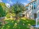 A spacious backyard featuring mature trees, green grass, fencing, and a home with ample windows at 4295 Cami Way, Buford, GA 30519