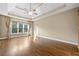 Bright bedroom featuring hardwood floors, a tray ceiling, and large windows with natural light at 4295 Cami Way, Buford, GA 30519