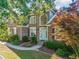 Charming brick home with a manicured front yard, beautiful landscaping and a light blue front door at 4295 Cami Way, Buford, GA 30519