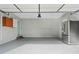 Spacious garage with epoxy floors, built-in storage, a stainless steel refrigerator, and a light blue door at 4295 Cami Way, Buford, GA 30519