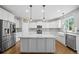 Modern kitchen with white cabinets, stainless steel appliances, an island, and hardwood floors at 4295 Cami Way, Buford, GA 30519