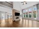 Open-concept living room featuring a fireplace, hardwood floors, large windows, and lots of natural light at 4295 Cami Way, Buford, GA 30519