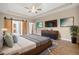 Staged main bedroom featuring tray ceiling, hardwood floors, modern ceiling fan, natural light and multiple TVs at 4295 Cami Way, Buford, GA 30519