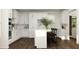 White kitchen with stainless steel appliances, island with seating, and hardwood floors at 243 Deer Valley Run, Canton, GA 30115