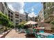 Community patio area with a grill, tables and chairs, a water feature, and mature trees at 390 17Th Nw St # 2040, Atlanta, GA 30363