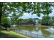 Scenic view of a pond with a pedestrian bridge, fountains, and surrounding lush greenery at 390 17Th Nw St # 2040, Atlanta, GA 30363