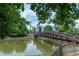 A tranquil pond surrounded by green trees and a bridge, offering a serene escape in the community at 390 17Th Nw St # 2040, Atlanta, GA 30363