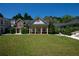 Grand home showcasing a manicured lawn, a welcoming front porch, and classic architectural details at 4790 Shallowford Rd, Roswell, GA 30075