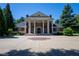Grand home with brick facade, prominent white columns, and a circular driveway creates a stately and impressive entrance at 4790 Shallowford Rd, Roswell, GA 30075