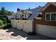 Spacious four-car garage with attached brick house featuring upper dormer windows and a well-manicured lawn at 4790 Shallowford Rd, Roswell, GA 30075