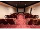 Spacious carpeted home theater with comfortable seating and a large screen for an immersive viewing experience at 4790 Shallowford Rd, Roswell, GA 30075