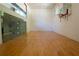 Spacious racquetball court with hardwood flooring, glass viewing wall, and a basketball hoop for recreational use at 4790 Shallowford Rd, Roswell, GA 30075