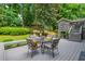 Spacious backyard with deck, dining area, seating, lush greenery, and mature trees for shade at 6505 Whispering Ln, Atlanta, GA 30328