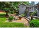 Inviting backyard sitting area with wooden chairs, lush greenery, and a charming fire pit at 6505 Whispering Ln, Atlanta, GA 30328