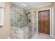 Tiled shower with glass enclosure featuring a rain shower head and a sliding barn door at 6505 Whispering Ln, Atlanta, GA 30328