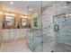 Modern bathroom showcasing a glass-enclosed shower with decorative tile work, and double vanities with framed mirrors at 6505 Whispering Ln, Atlanta, GA 30328