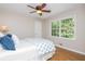 Bright bedroom with hardwood floors, a large window with a view of the backyard, and a cozy bed with blue accents at 6505 Whispering Ln, Atlanta, GA 30328