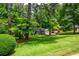 Landscaped front yard featuring mature trees and meticulously maintained lawn at 6505 Whispering Ln, Atlanta, GA 30328